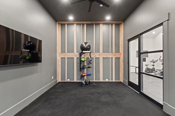 room with gym equipment and a large window and a ceiling fan at Hadley Place Apartments, Enola